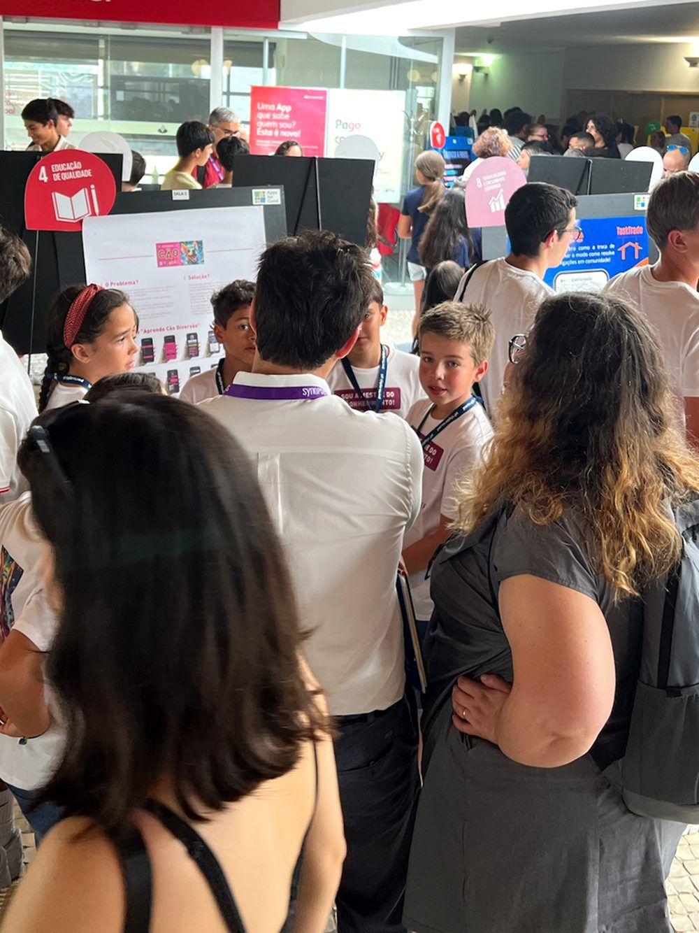Image of children presenting their app Aprende Cao Diversao to 2 members of a Juri while all stading up. This is an image related to a project inside Pedro Rodrigues (Treze413) graphic design portfolio.