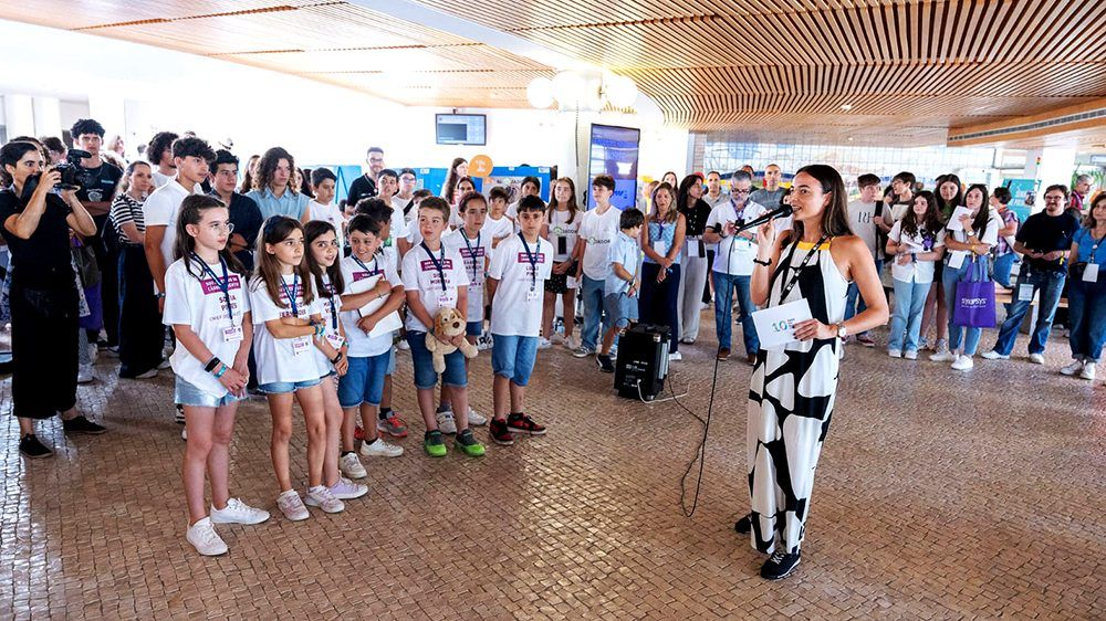 Image of a lot of people standing up at one event while the host opens this event. 8 children are standing up on the first line.. This is an image related to a project inside Pedro Rodrigues (Treze413) graphic design portfolio.